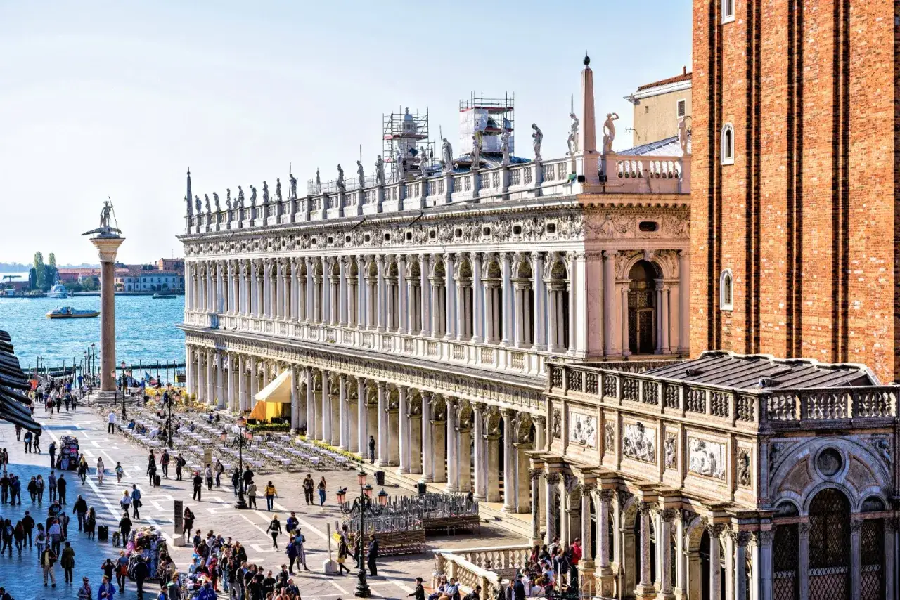 La bibliothèque Marciana de Venise, avec sa façade ornée, borde une place animée.