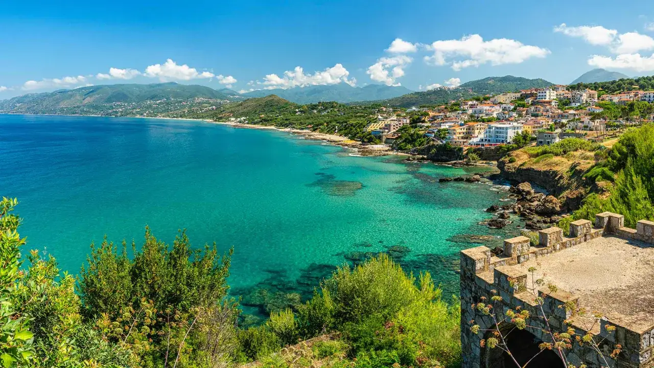 Vue panoramique sur la c&ocirc;te du Cilento en Italie, avec des eaux turquoise cristallines, des villages perch&eacute;s et des ruines de ch&acirc;teau.
