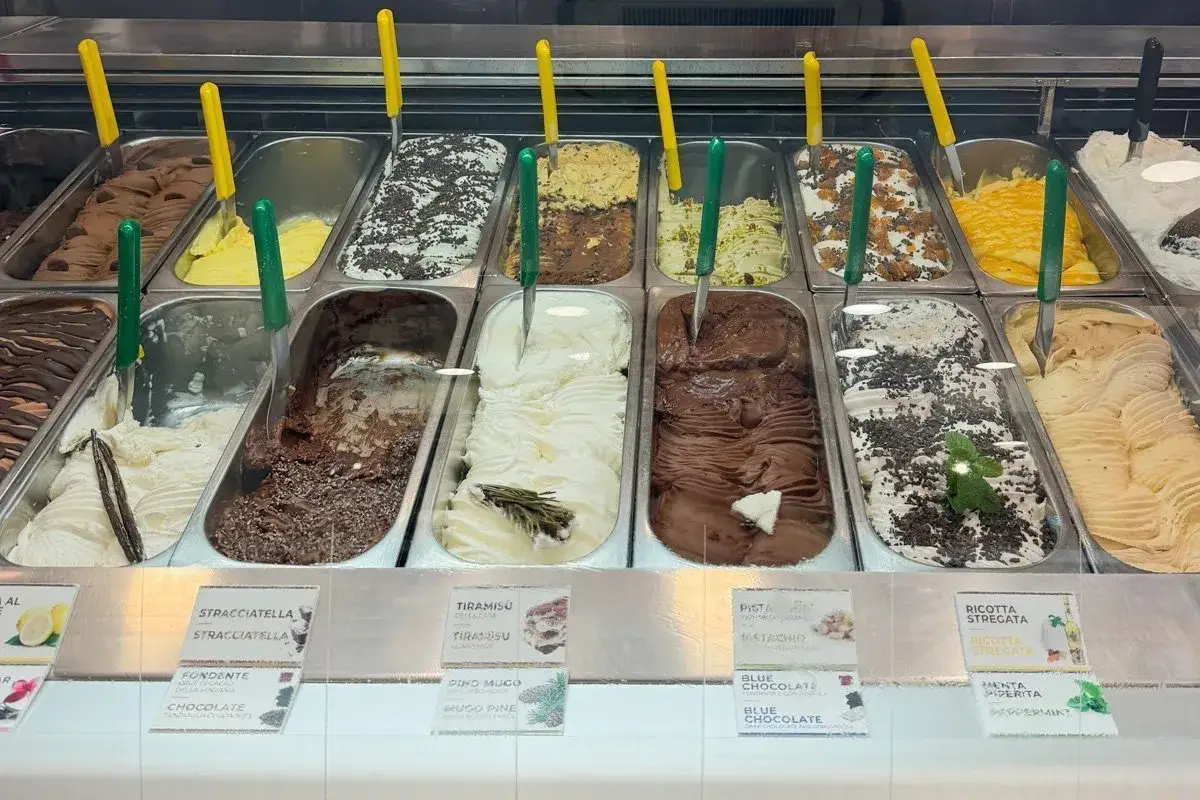 Un étalage de glaces artisanales à Rome, avec des parfums variés comme le chocolat, la pistache et la stracciatella.