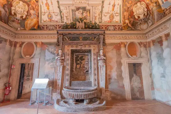 Intérieur de la Villa d'Este : une fontaine ornée de sculptures et de fresques murales dépeignant des scènes mythologiques et des paysages.
